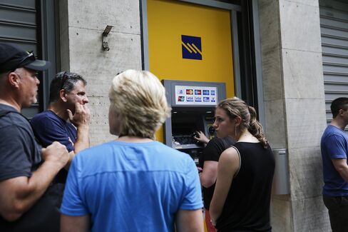 People wait in line at an ATM at a bank in Athens