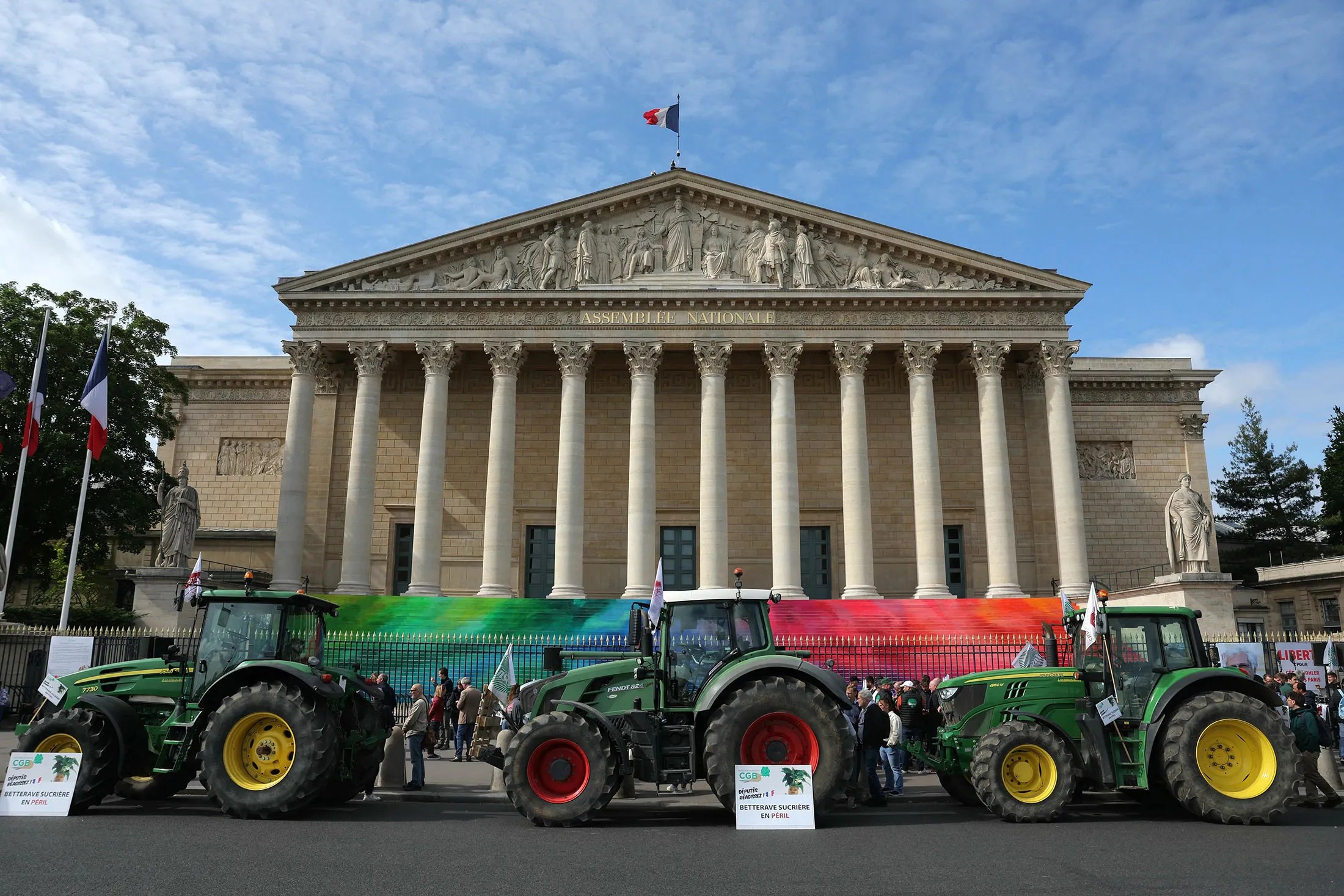 Farmers stand next to tractors during a rally outside the French National Assembly in Paris&nbsp;on May 26.