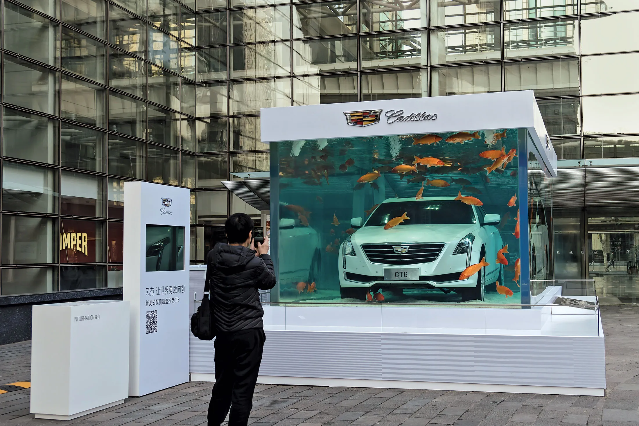 A Cadillac CT6 inside an aquarium tank grabs the attention of a passerby in a trendy Shanghai shopping district.
