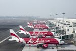 AirAsia Bhd. aircraft stand next to boarding gates at Kuala Lumpur International Airport. 