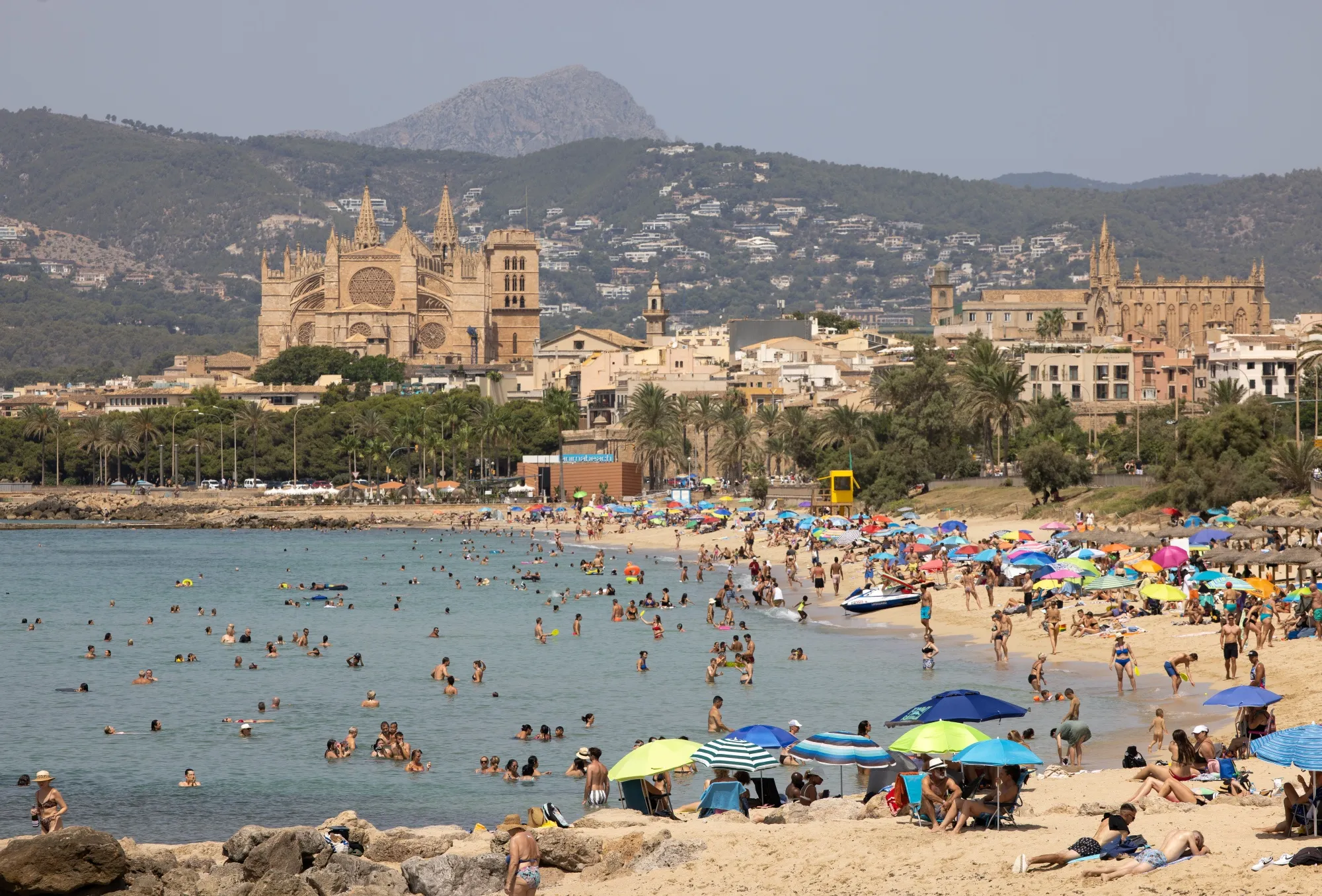 Visitors on the beach in Palma de Mallorca, Spain.