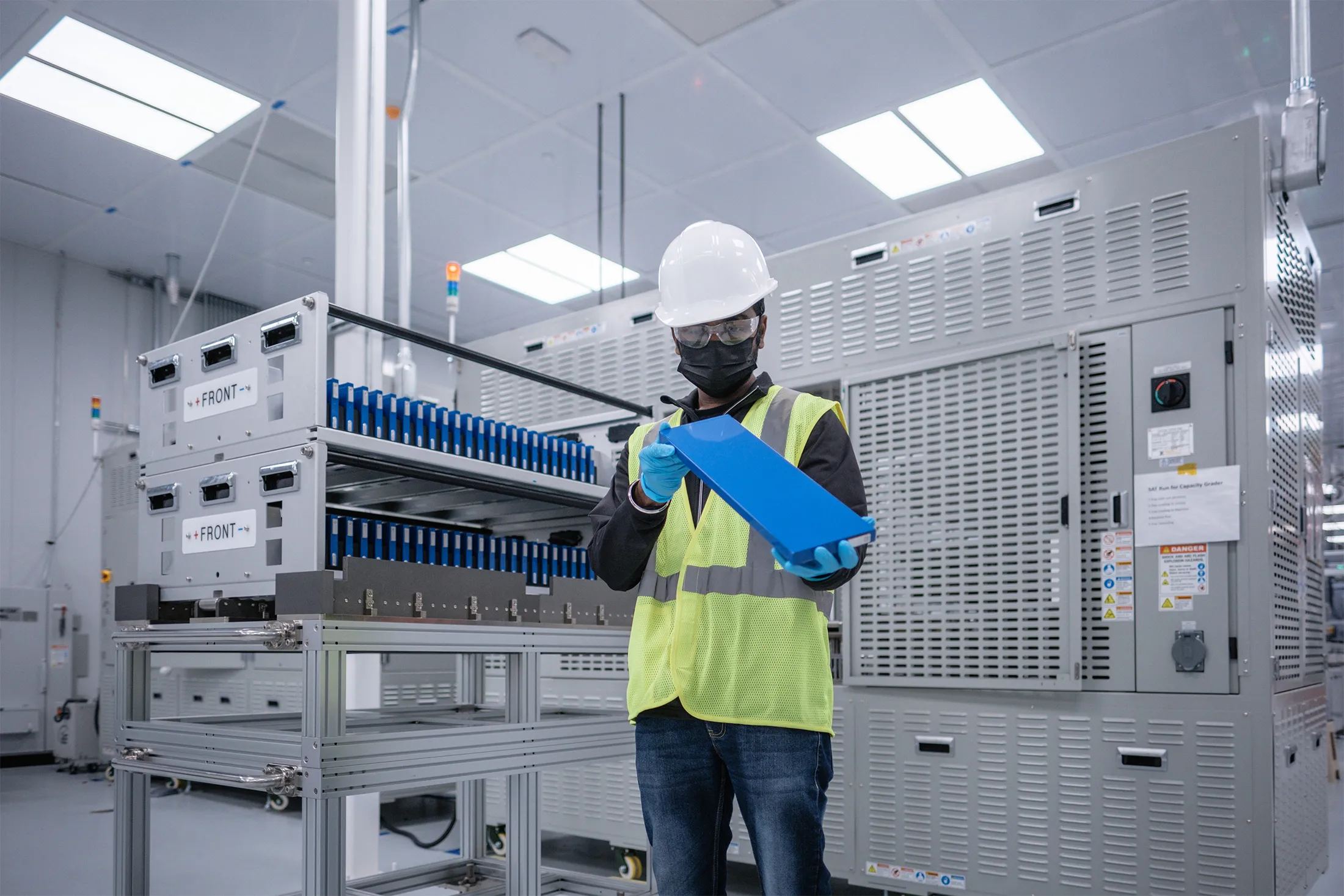 An employee at ONE’s Van Buren, Michigan, plant shows off an LFP prototype cell.