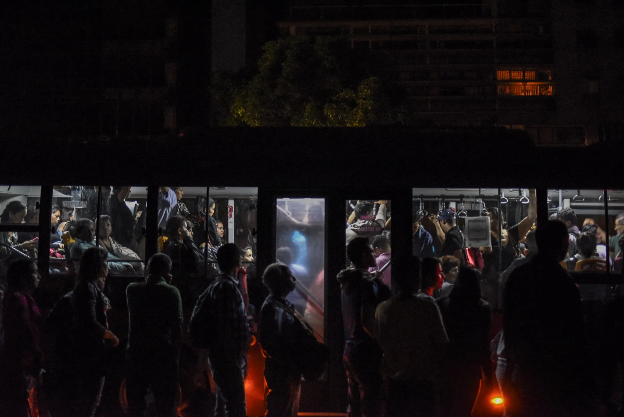Residents wait for a bus during a major blackout in Caracas on March 7.