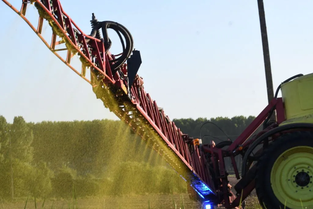 A farmer sprays fertiliser.