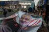 People prepare to hang a poster of Qassem Soleimani, an Iranian commander, following a U.S. airstrike in Iraq, in Tehran, Iran, on Sunday, Jan. 5, 2020. 