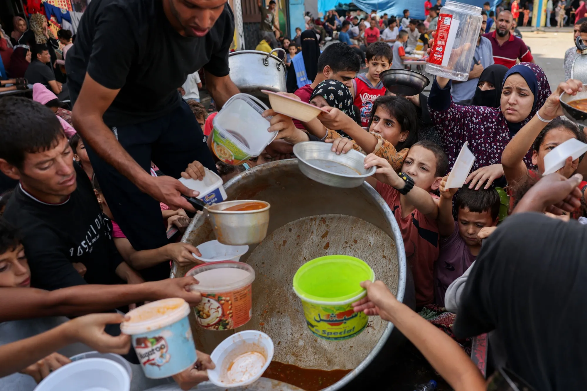 Palestinian children receive food at a UN-run school in Rafah, Gaza&nbsp;on Oct. 23.