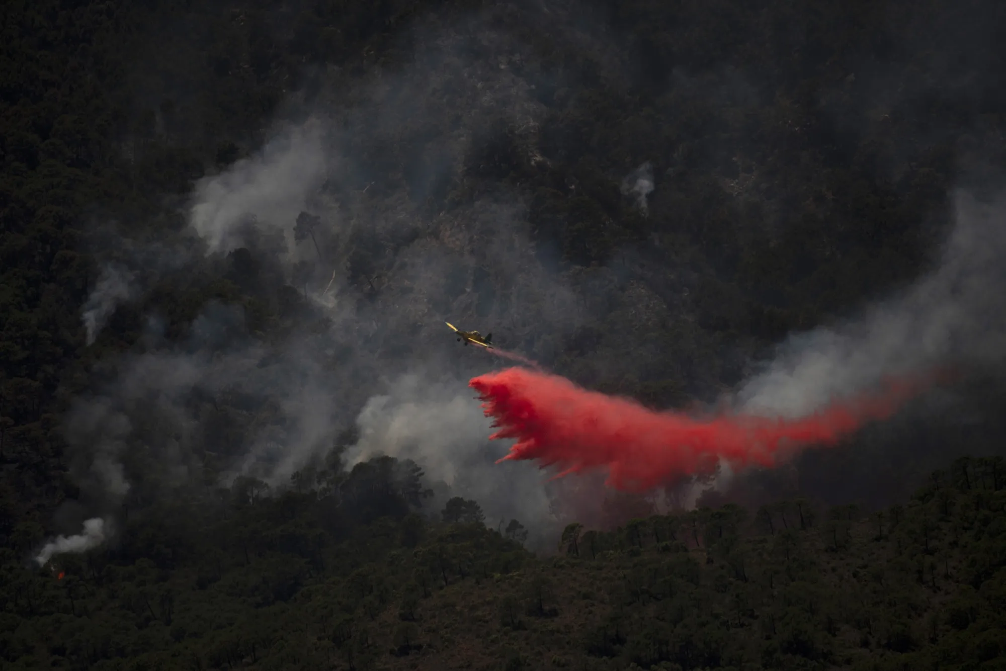 A helicopter dumps fire retardant onto a wildfire at the Sierra Bermeja mountain in Spain on June 10.