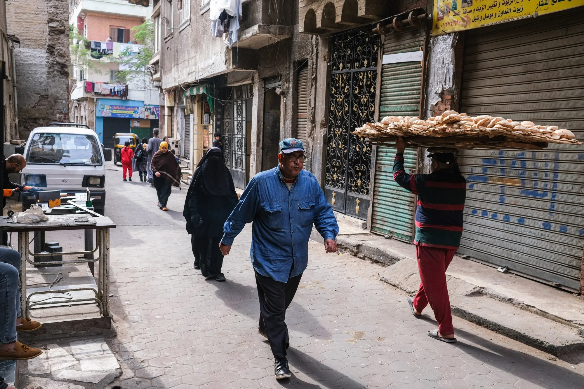 A worker carries a tray of freshly baked bread in the Al-Khalifa district of Cairo, Egypt.