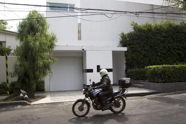 A motorcyclist passes in front of the house recently acquired by First Lady Angélica Rivera in Mexico City