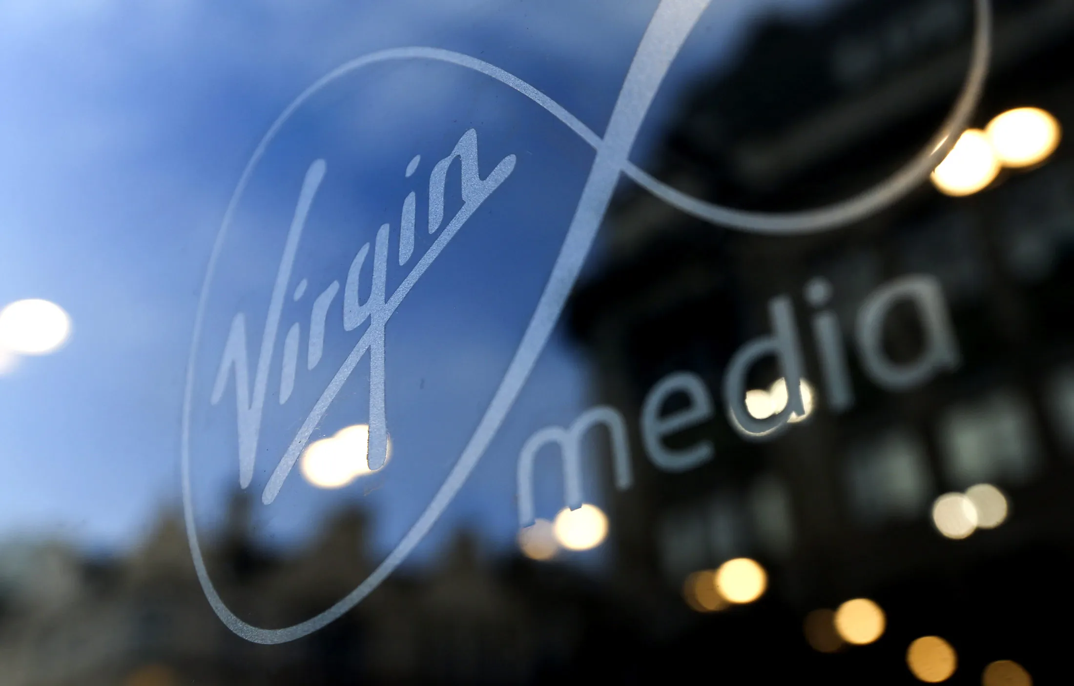 The Virgin Media company sign is displayed on the window of the company's Oxford Street in London, U.K., on Wednesday, Feb. 6, 2013. Billionaire John Malone's Liberty Global Inc. agreed to acquire Virgin Media, Britain's second-largest pay-TV provider, in a $16 billion cash-and-stock transaction announced in the U.S. yesterday.
