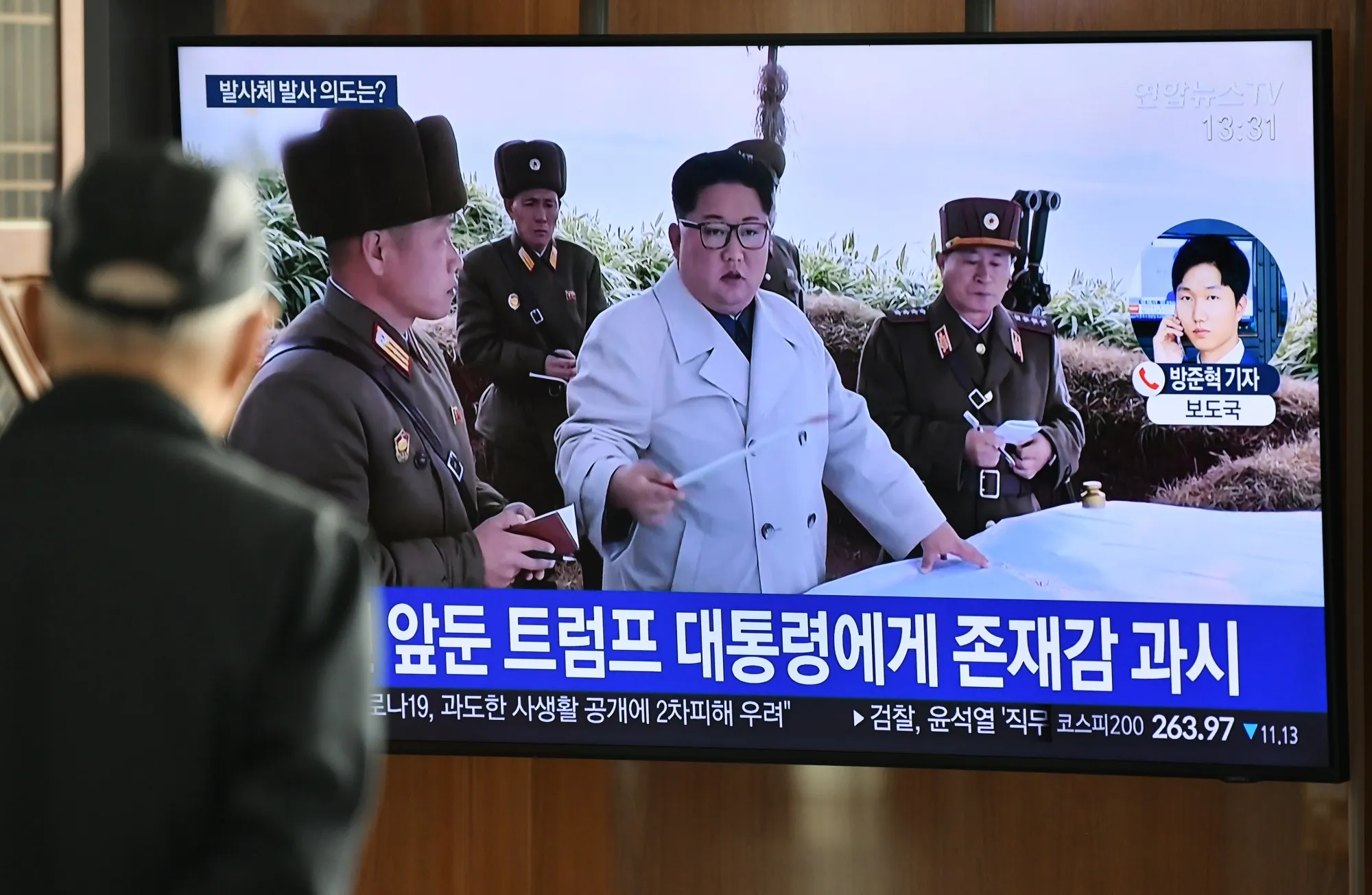 A man watches a television news broadcast showing file footage of North Korea's leader Kim Jong Un, at a railway station in Seoul.