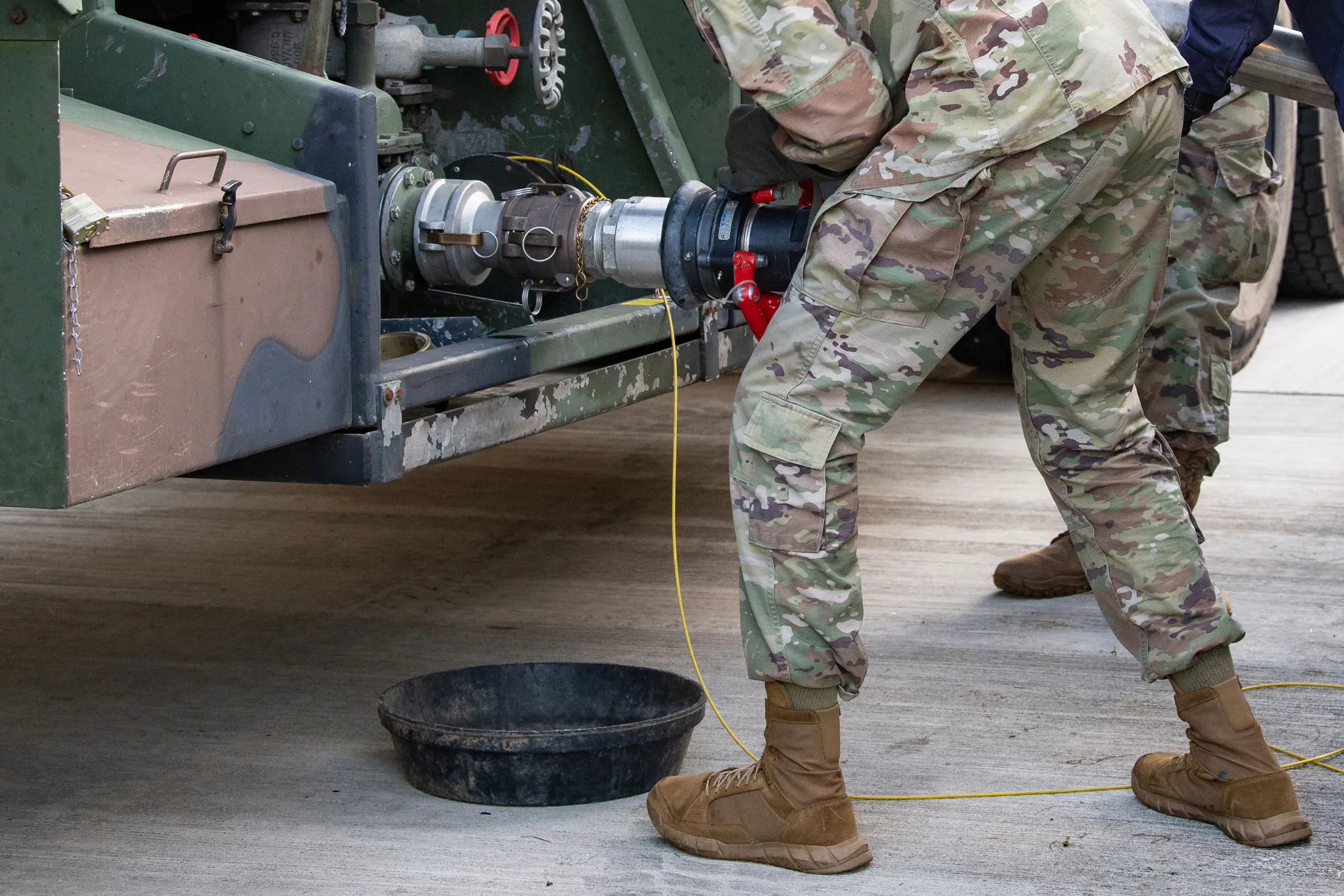 A US soldier connects a jet fuel pump to a M969 semi-trailer tanker at a Central Europe Pipeline System site Bitburg, Germany.