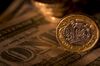 A stack of British one pound coins stand on an arrangement of a US one dollar banknotes in this arranged photograph in London, U.K., on Monday, July 22, 2019. The pound may fall to parity with the dollar on a no-deal Brexit, according to Morgan Stanley.
