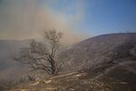 Smoke rises on a burnt hillside during a brush fire in Los Angeles, California, U.S.