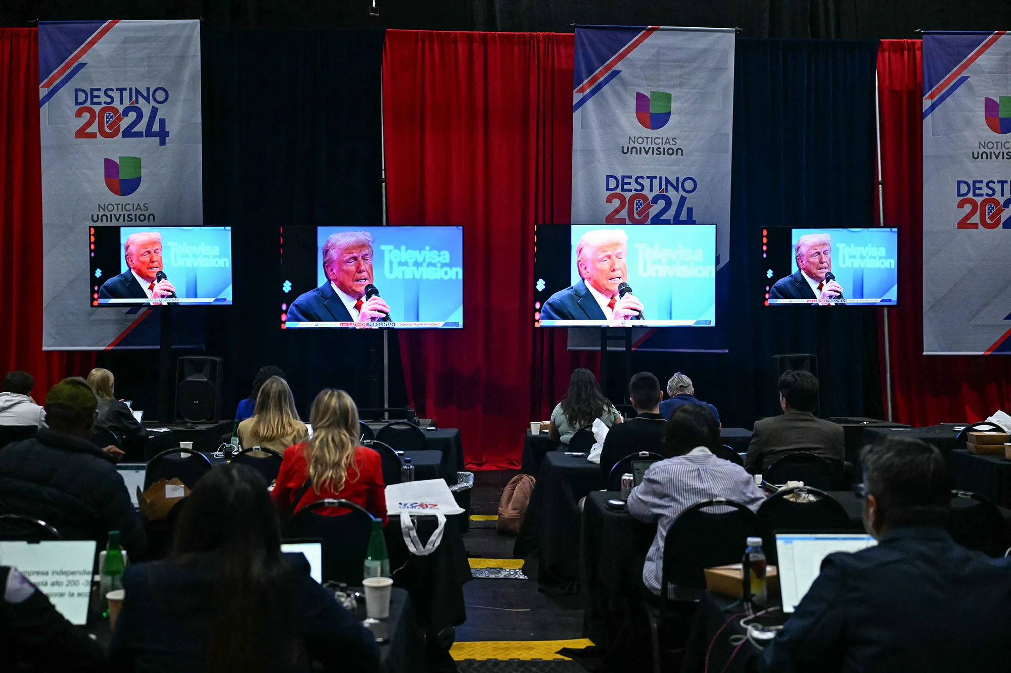 Journalists watch as Donald Trump is displayed on a monitor during a town hall hosted by Univision in Miami, Florida, on Oct. 16.