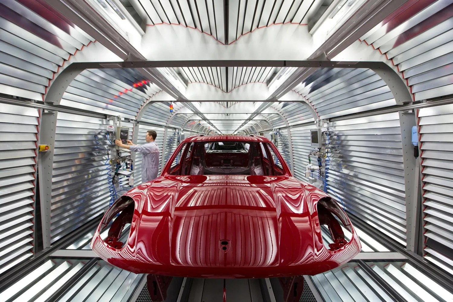 The body of Porsche Panamera luxury automobile stands inside a light tunnel during paint work inspections in the Porsche AG factory in Leipzig.
