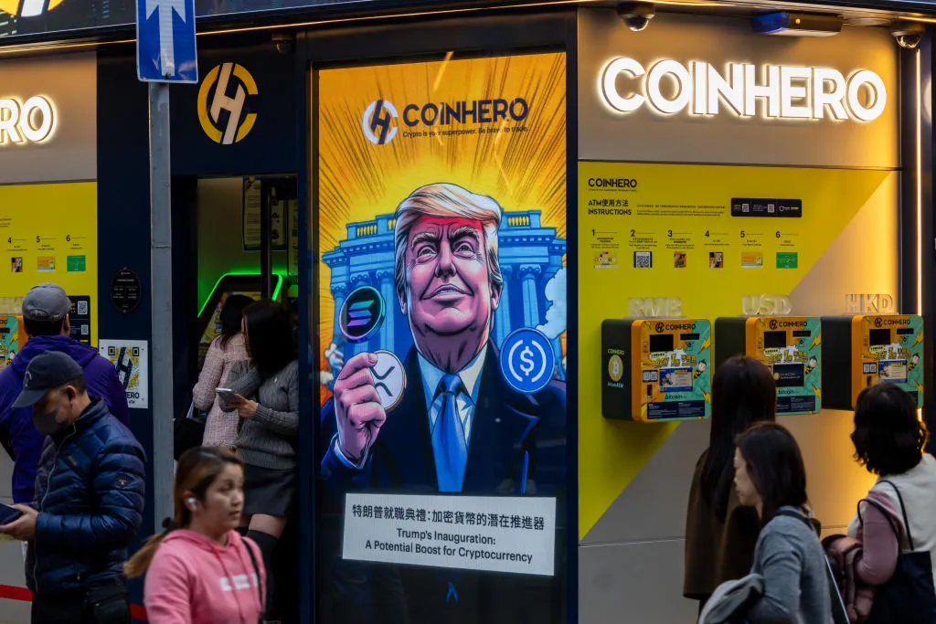 A cartoon image of US President-elect Donald Trump with cryptocurrency tokens displayed at a Coinhero store in Hong Kong.