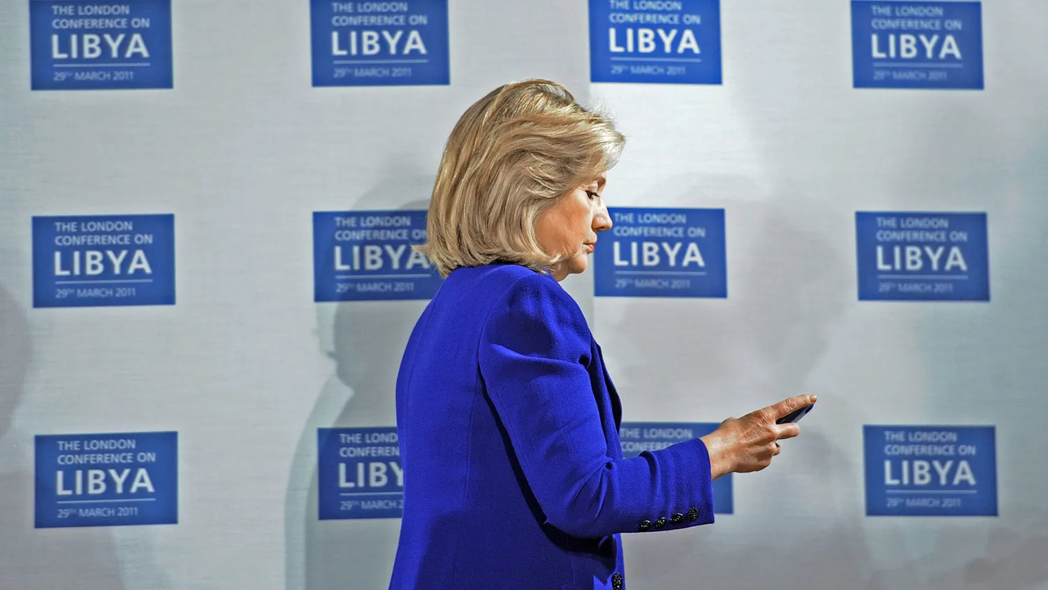 U.S. Secretary of State Hillary Clinton checks her phone at the opening of the Libyan Conference, a meeting of international allies to discuss the next steps for Libya on March 29, 2011 in London, England.
