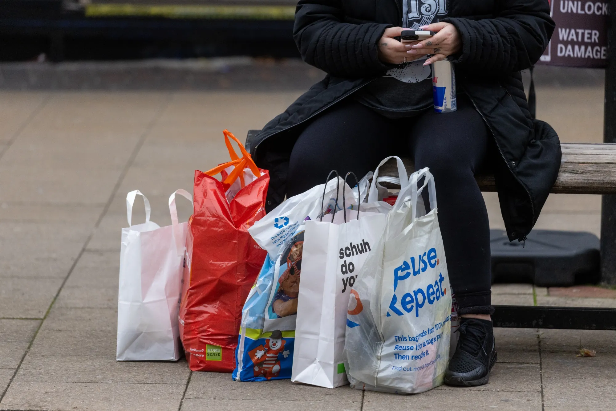 A shopper sits on a bench on the high street of Bexleyheath, London