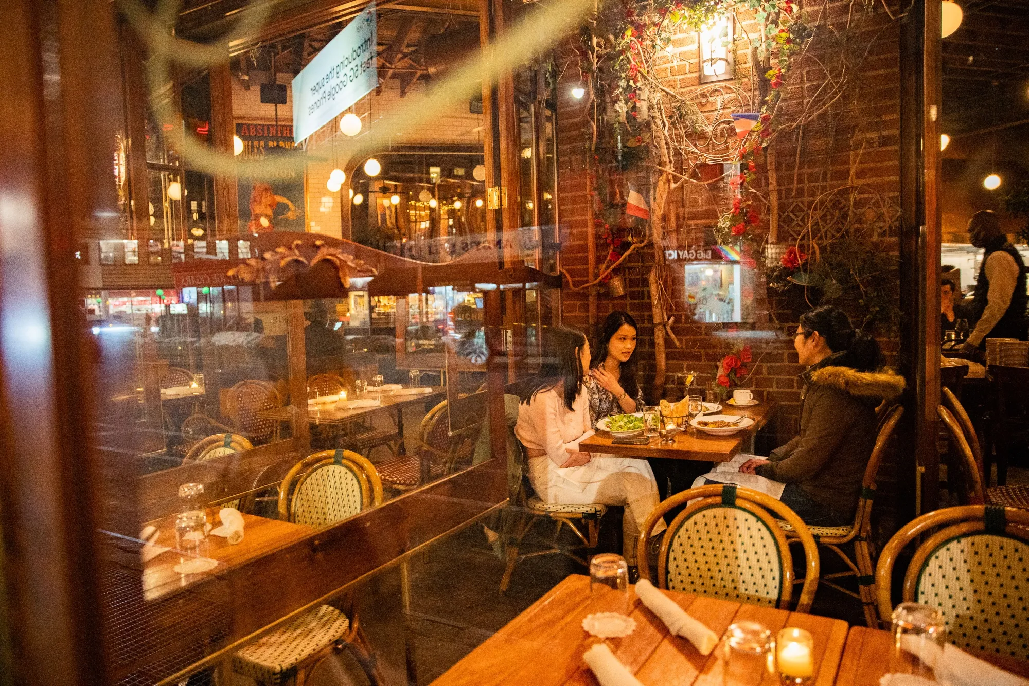 People eat in the outdoor seating area of the Boucherie restaurant in the West Village.