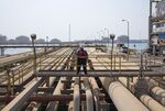 An employee looks over oil pipes at the North Pier Terminal in Ras Tanura, Saudi Arabia.