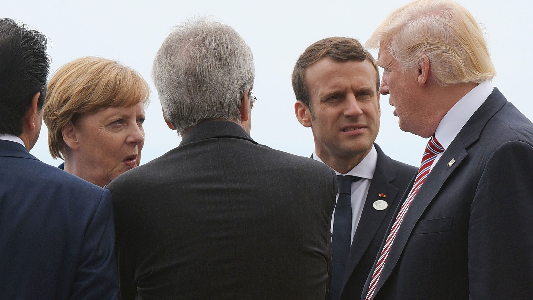 Merkel and Macron listen to Trump during a G7 summit on May 26.
