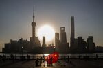 A man carrying a kite in the shape of the Chinese national flag walks along the Bund in Shanghai