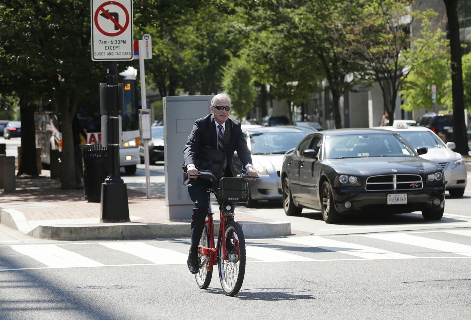 A man wearing suit uses a Capital Bikeshare during rush hour in downtown Washington, D.C.