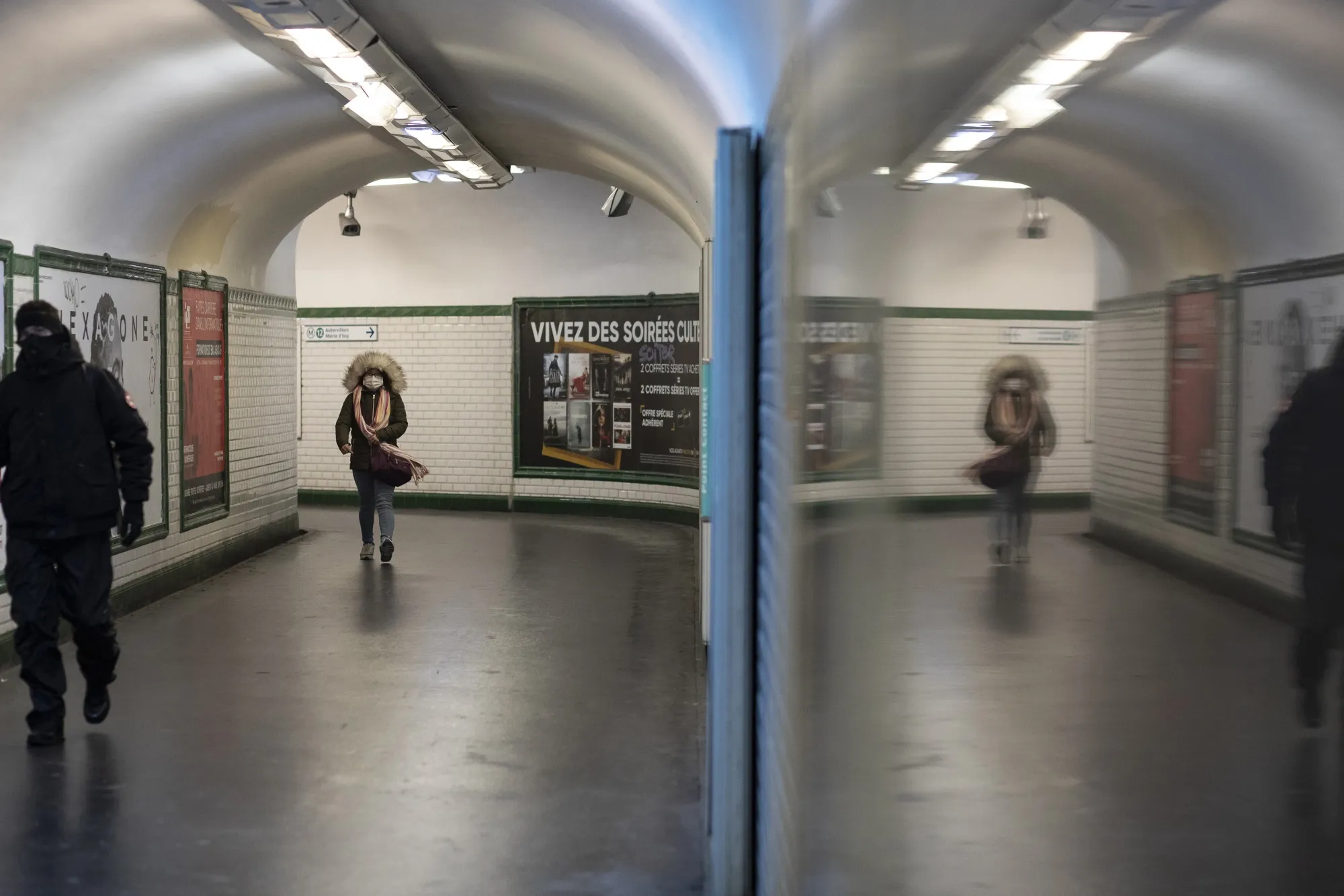 A commuter wearing a face mask walks along an underground passage at a metro station in Paris on March 16.