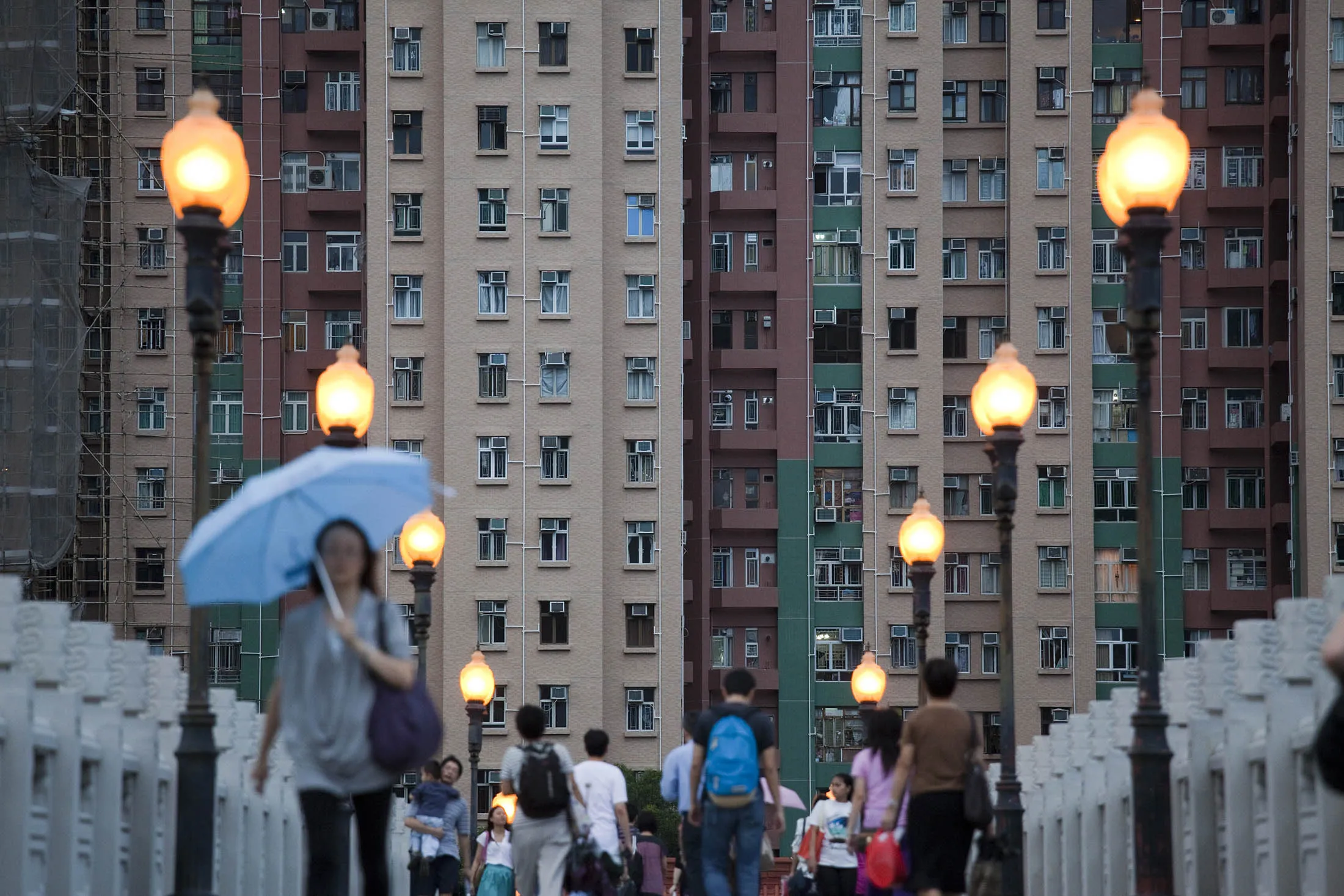 Pedestrians walk near residential buildings in the Sha Tin area of Hong Kong, China.
