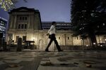 A pedestrian walks past the Bank of Japan (BOJ) headquarters at dusk in Tokyo, Japan, on Monday, Sept. 14, 2020.