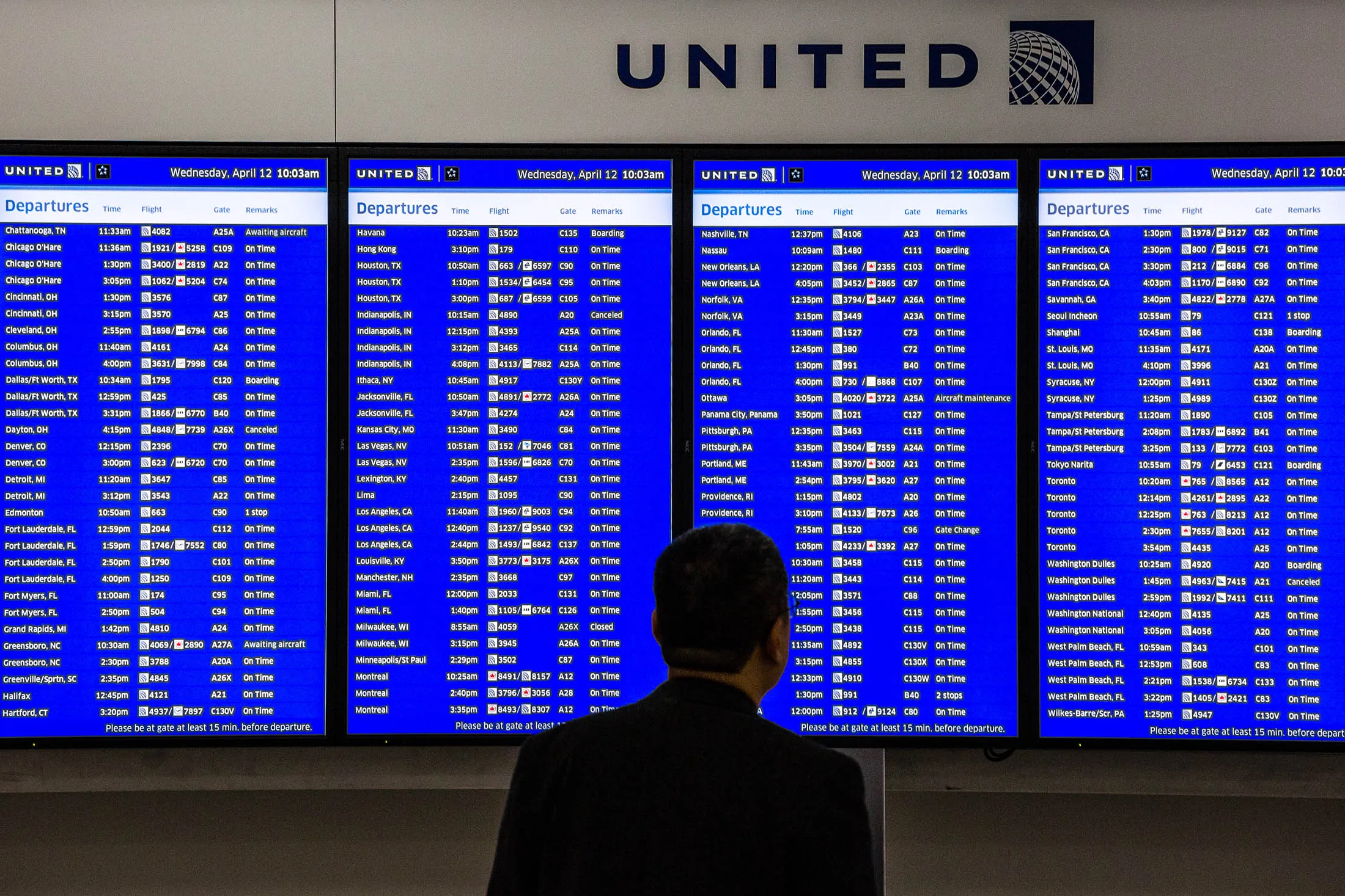 A passenger views a departures board inside the United Continental Holdings Inc. terminal at Newark Liberty International Airport (EWR) in Newark, New Jersey, U.S., on Wednesday, April 12, 2017. United Airlines is under fire for forcibly removing a passenger from a plane in Chicago shortly before departure to make room for company employees, an incident which demonstrates how airline bumping can quickly veer into confrontation.
