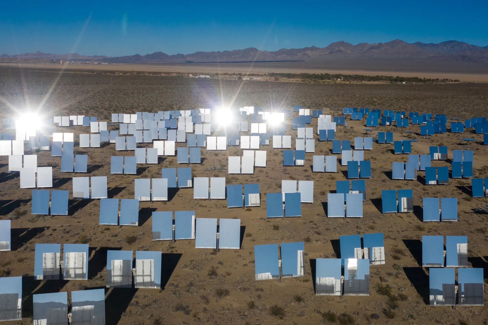Heliostatic mirrors reflect sunlight at a solar farm in the California desert.