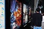 Movie goers line up next to an advertisement for 'Demon Slayer: Kimetsu no Yaiba' outside a movie theater in Tokyo on Oct. 31.