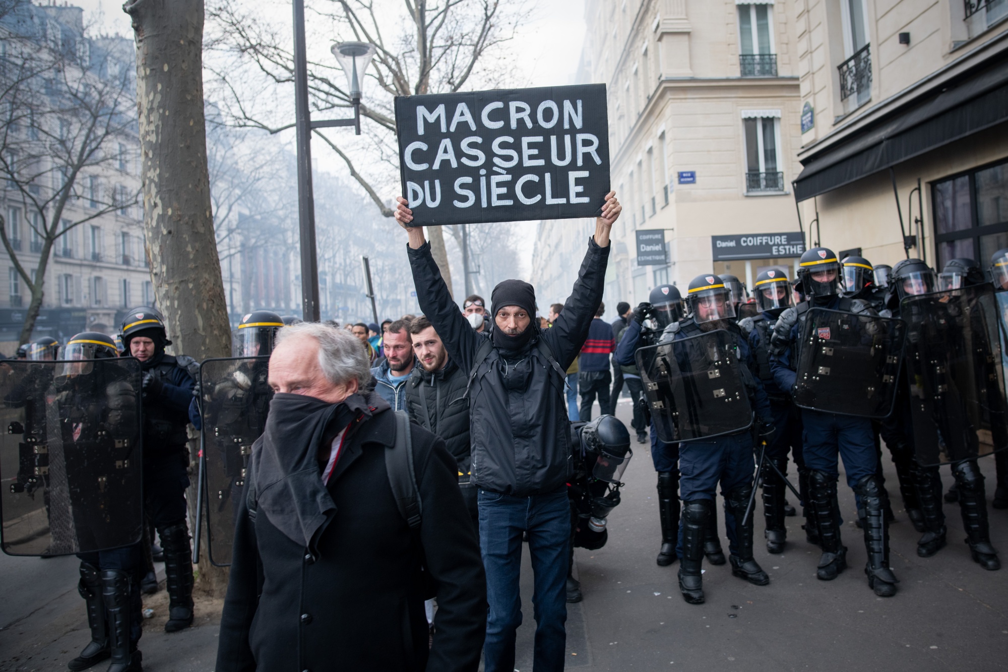 A demonstrator holds an anti Macron placard at a protest against the pension system, in Paris.&nbsp;