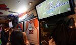 Football fans watch an NFL game at a bar.
