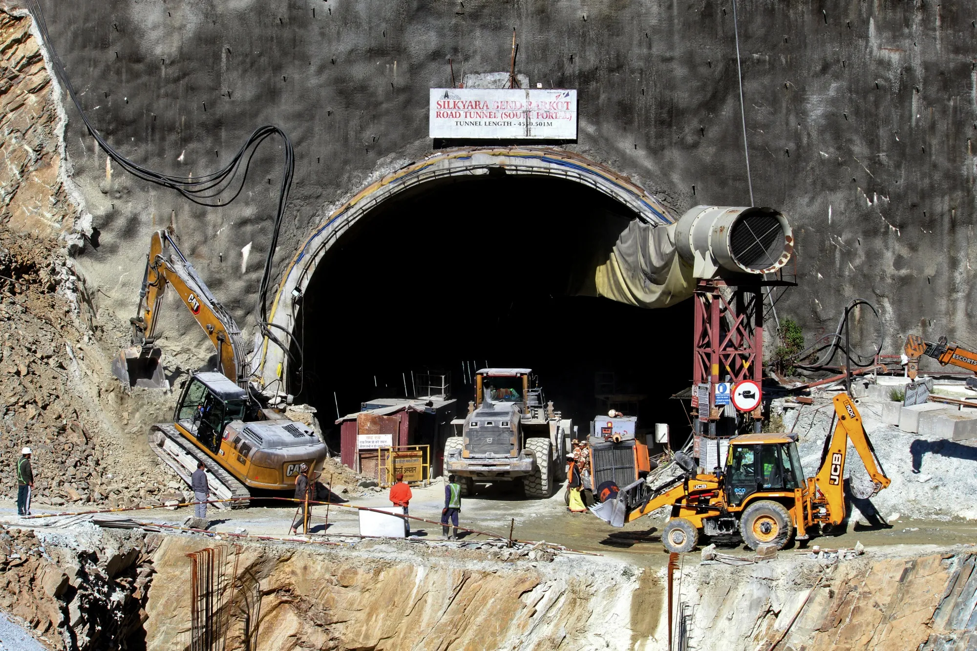 Rescue workers at an entrance of the under construction road tunnel, days after it collapsed.