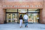 Employees enter the administrative offices of Banca Monte dei Paschi di Siena in Siena, Italy.