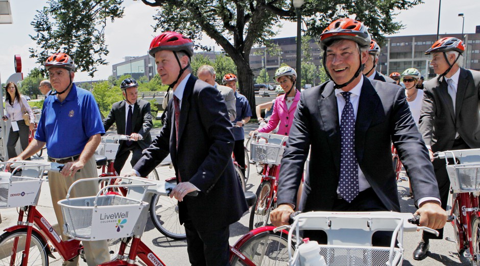 Former Denver Mayor John Hickenlooper (center) wore a helmet for the unveiling of the city's Bcycle bike-share system. But do any of its users?