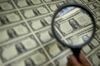 A magnifying glass is held over a 50 subject one dollar note sheet after being printed by an intaglio printing press in this arranged photograph at the U.S. Bureau of Engraving and Printing in Washington, D.C., U.S., on Tuesday, April 14, 2015.