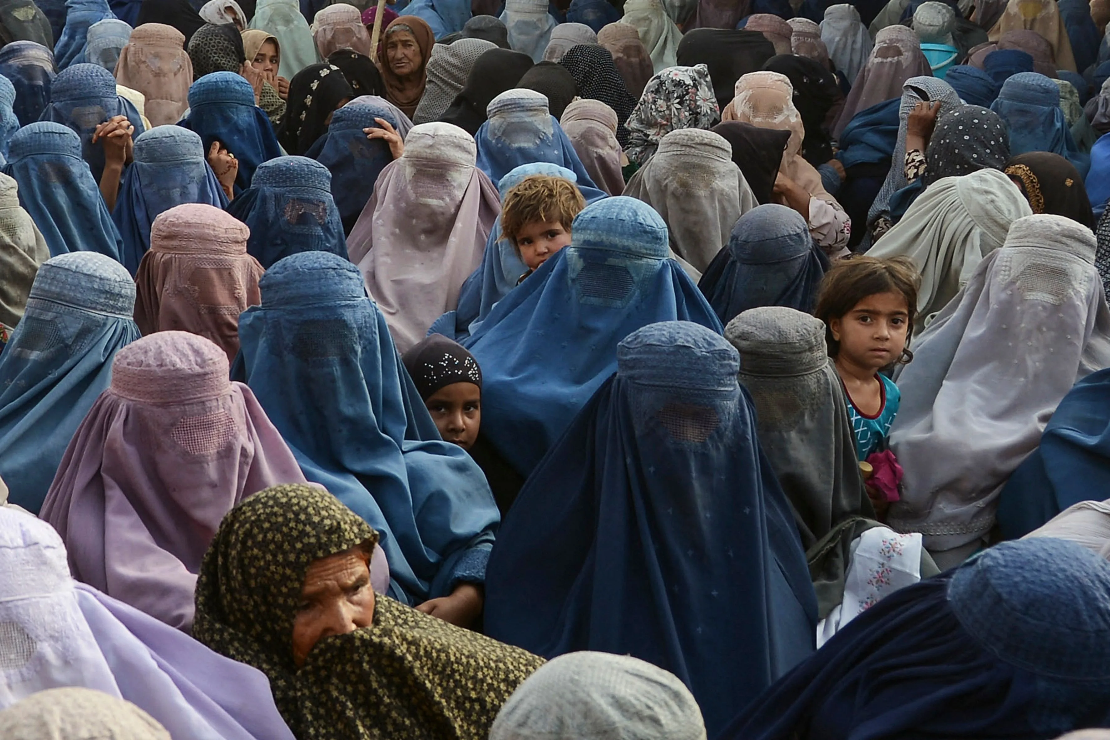 Women with their children wait to receive a food donation during&nbsp;Ramadan in Kandahar on April 27.
