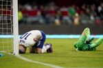 United States' Christian Pulisic, left, and Mexico's goalkeeper Guillermo Ochoa grimace on the ground following a clash during a qualifying soccer match for the FIFA World Cup Qatar 2022 at Azteca stadium in Mexico City, Thursday, March 24, 2022. (AP Photo/Eduardo Verdugo)