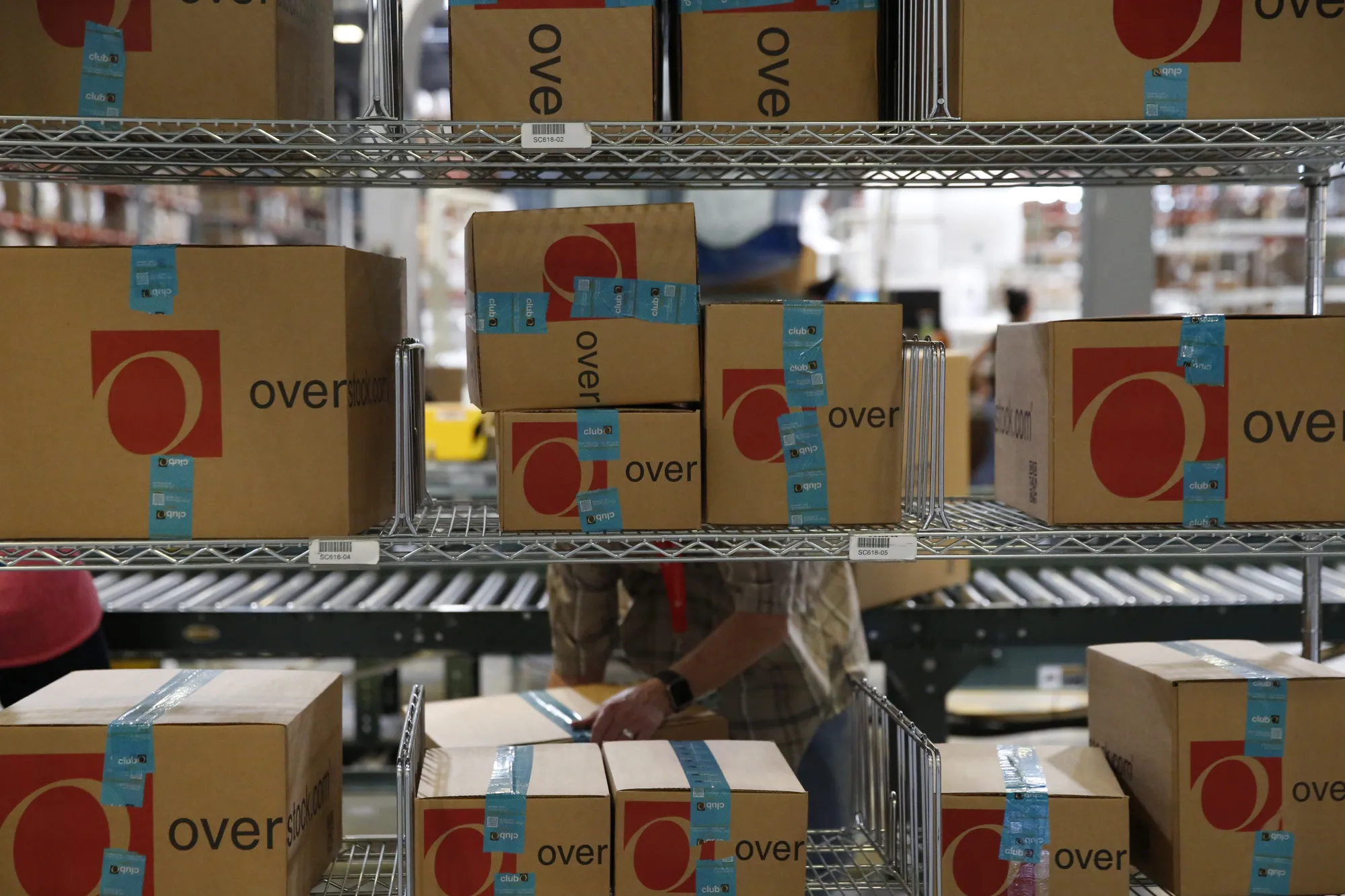 A worker places packages on shelves at the Overstock.com fulfillment center in Salt Lake City, Utah.