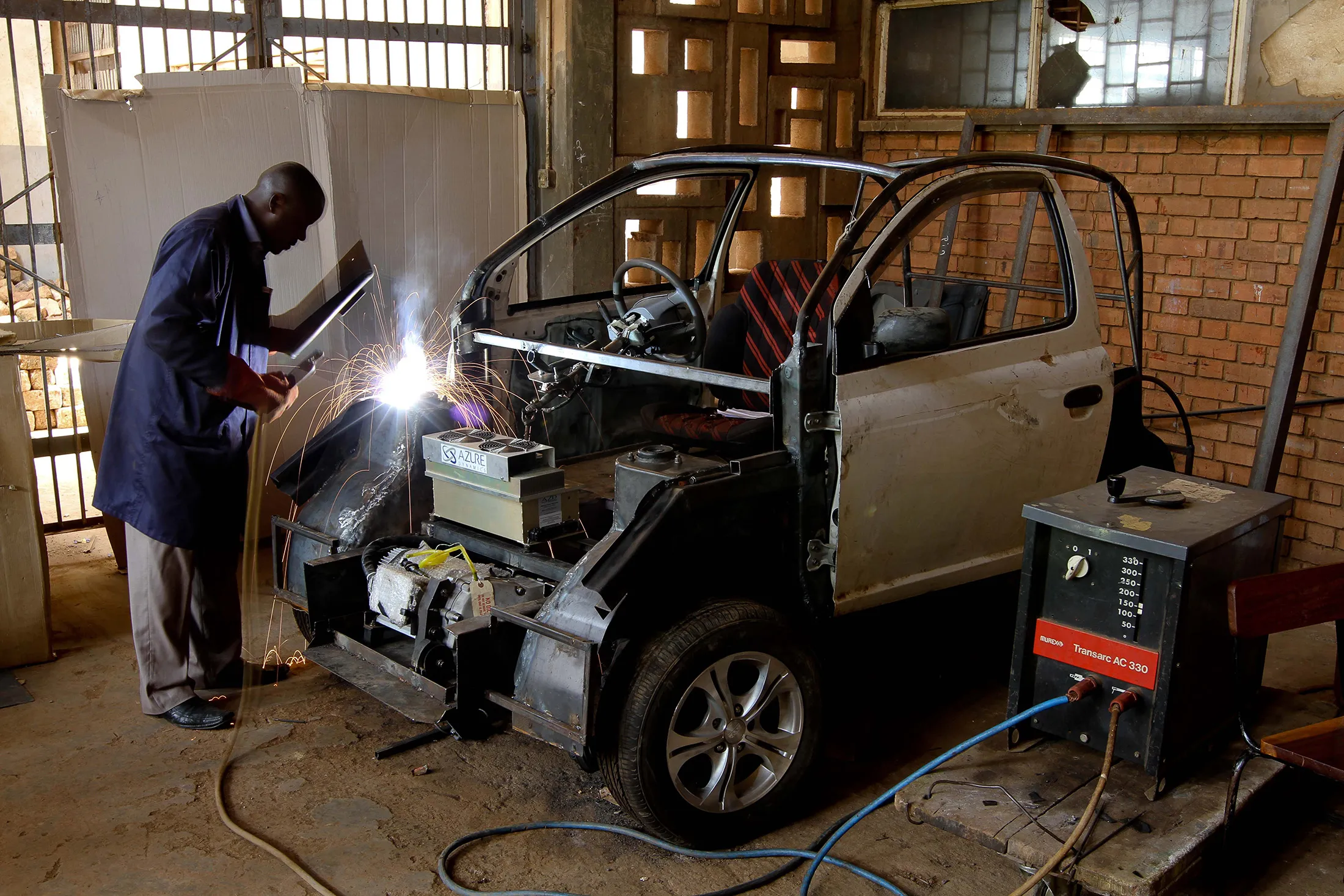 A project assistant at&nbsp;Makerere University works on a Kiira&nbsp;electric vehicle in Kampala, Uganda in 2011.