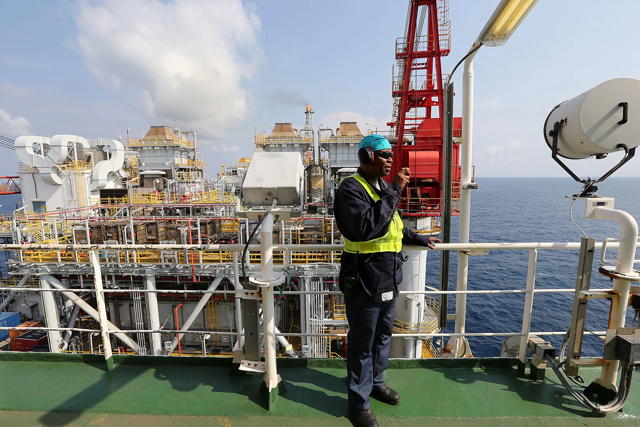 An employee communicates by radio aboard the a floating oil production, storage and offloading vessel, in the Agbami deepwater oilfield in the Niger Delta, Nigeria, on Dec. 2, 2015.
