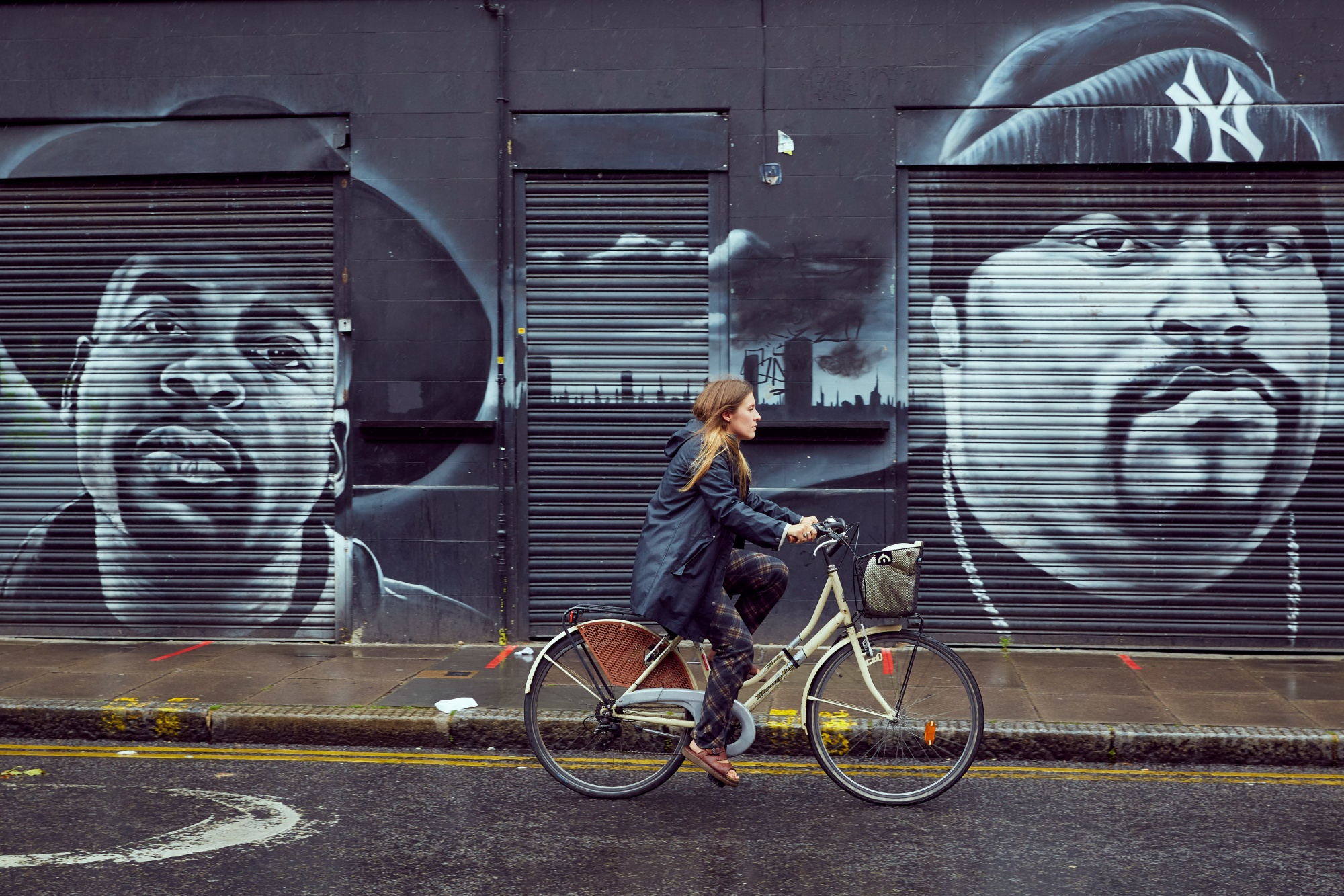 A cyclist passes murals on shop shutters at the junction of Coldharbour Lane and Atlantic Road in the Brixton district of London.&nbsp;To curb cars, the city is establishing several “low-traffic neighborhoods” in the area.&nbsp;