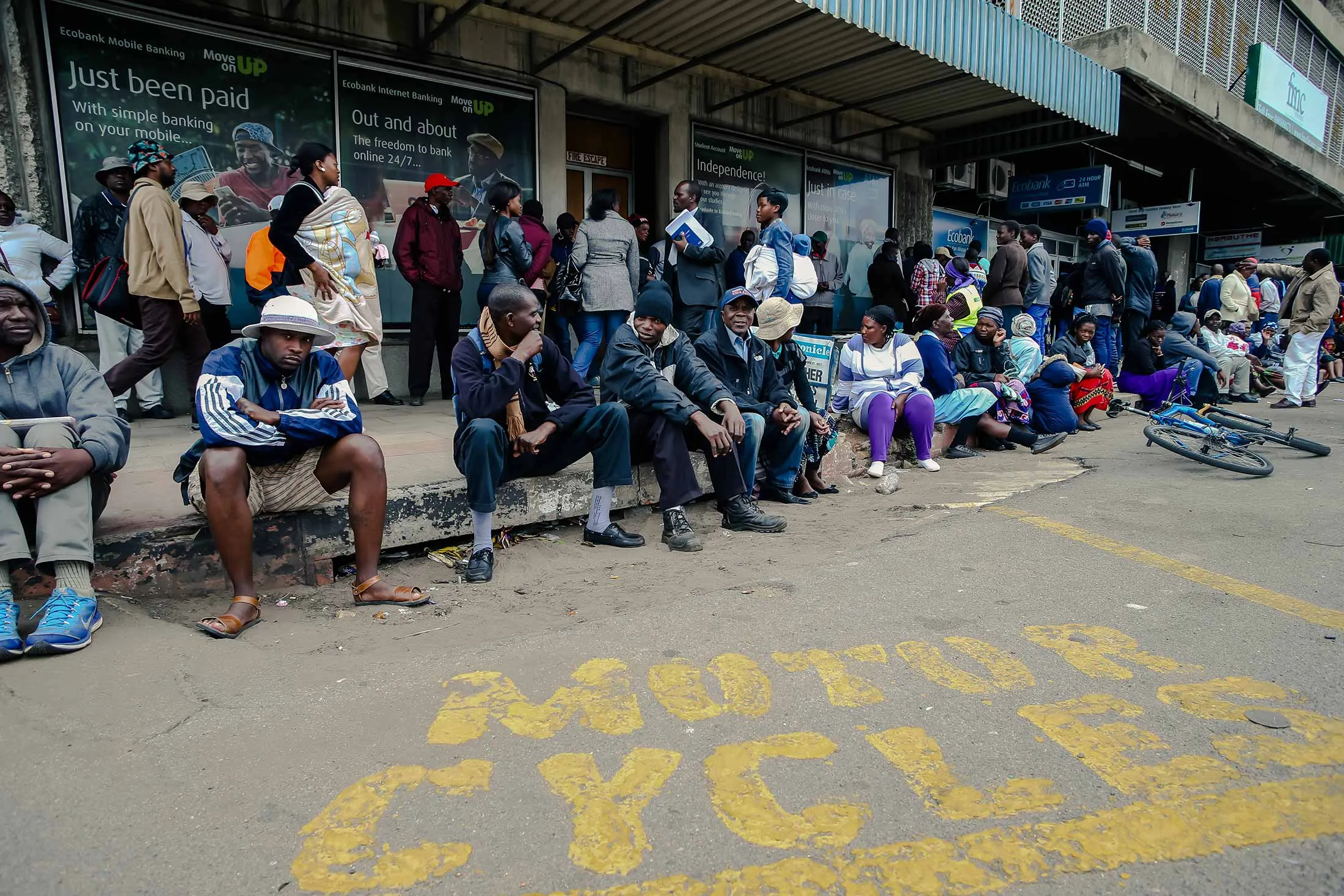 As a liquidity crisis continues, bank customers queue up in Bulawayo on Dec. 27. Zimbabweans must wait long hours to withdraw money from their accounts.