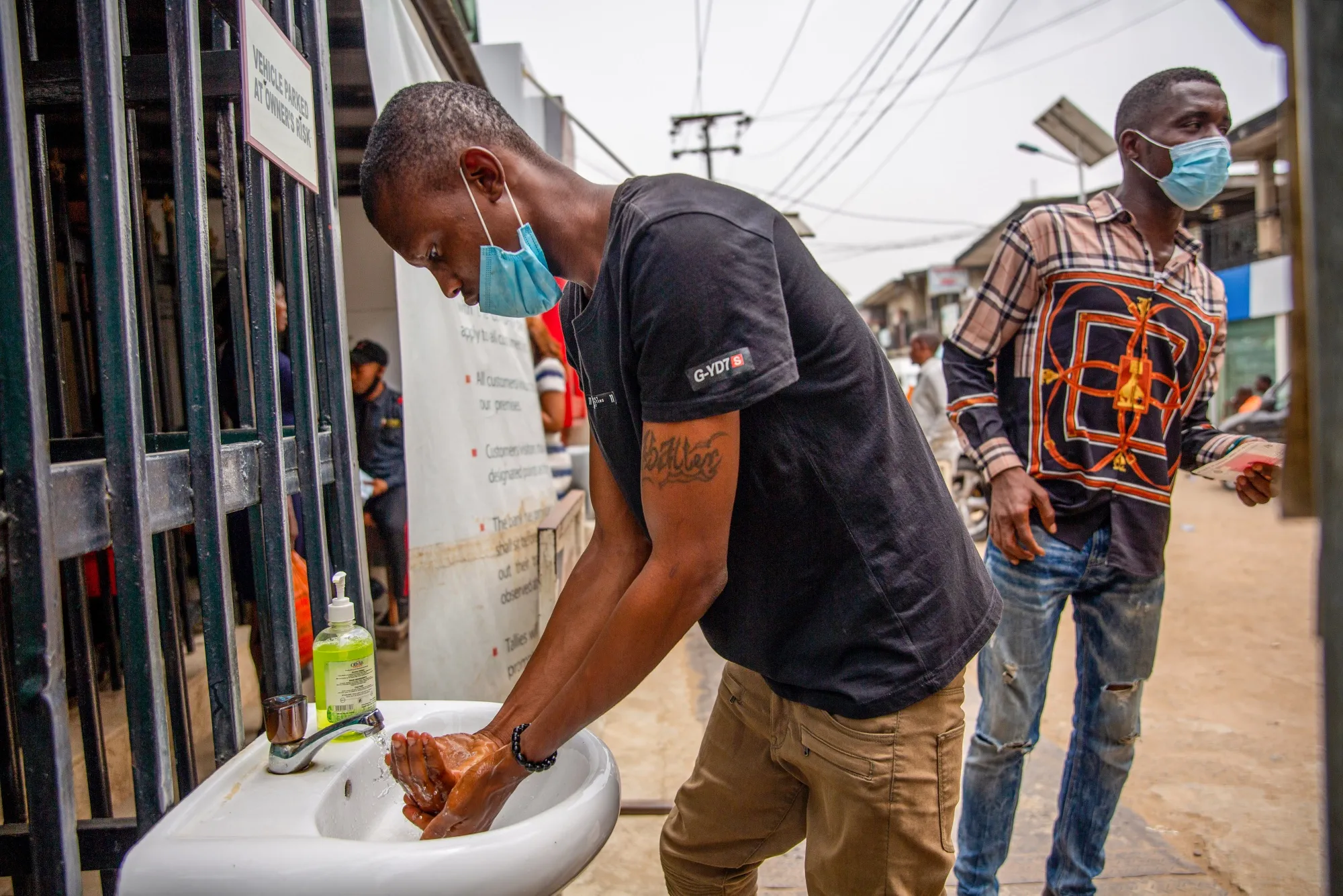 A shopper stops to wash his hands at the entrance to a market in Lagos, Nigeria.