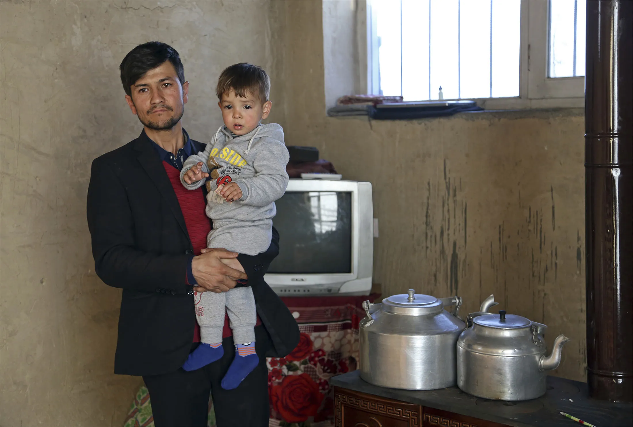 Asadullah Poya with his 18-month-old son Donald Trump, poses for a photograph at their rented house in Kabul, Afghanistan, Thursday, March 15, 2018.
