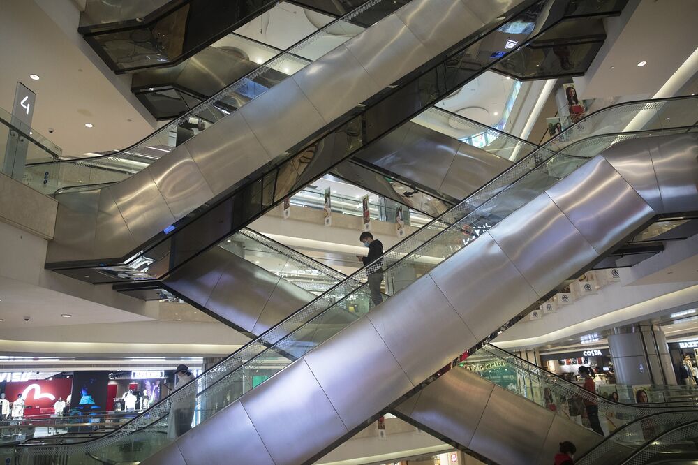 A customer rides an escalator in Wuhan international plaza on March 30.